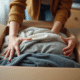 Jeune femme emballant des vêtements usagés pour expédition